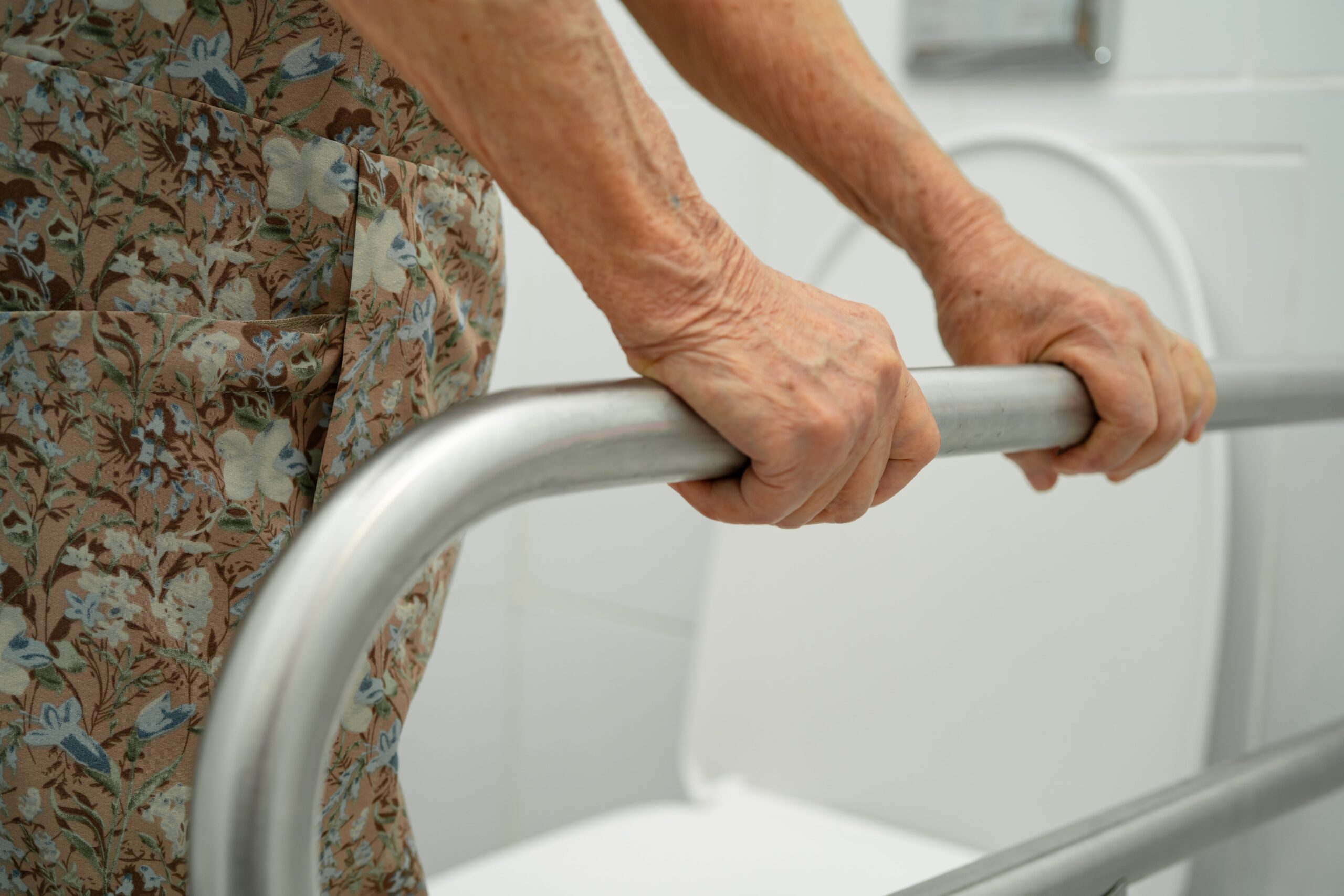elderly woman use toilet support rail in bathroom