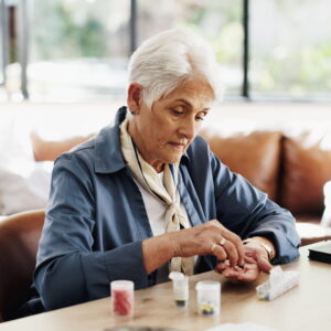 Elderly person organising her pills in a Pill Organisers